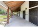 Covered walkway of barn features concrete floor, wooden support columns, and black sliding doors at 3810 Hidden River Rd, Sarasota, FL 34240