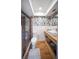 Updated bathroom with modern vanity, decorative wallpaper, and glass enclosed shower at 3810 Hidden River Rd, Sarasota, FL 34240