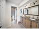 Bathroom featuring double sinks, vanity, mirror and adjoining toilet area at 3810 Hidden River Rd, Sarasota, FL 34240