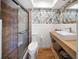 Updated bathroom with modern vanity, decorative wallpaper, and glass enclosed shower at 3810 Hidden River Rd, Sarasota, FL 34240