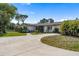 Charming single-story home showcasing a well-manicured lawn, mature trees, and a welcoming entrance at 3810 Hidden River Rd, Sarasota, FL 34240