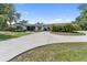 Charming single-story home featuring a circular driveway, mature trees, and lush landscaping at 3810 Hidden River Rd, Sarasota, FL 34240
