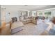 Cozy living room with a sectional sofa, patterned rug, and views of the fenced pasture at 3810 Hidden River Rd, Sarasota, FL 34240