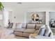 Bright living room featuring a sectional sofa, round mirror, and a glimpse of the bedroom at 3810 Hidden River Rd, Sarasota, FL 34240