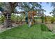 Backyard playground features a slide, swings, climbing structure, and comfortable green turf at 3810 Hidden River Rd, Sarasota, FL 34240