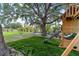 Tree shaded backyard playground area with a swing set, slide and rope ladder at 3810 Hidden River Rd, Sarasota, FL 34240