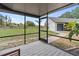 Screened-in porch with view of horses grazing in lush pasture, complementing the modern home's exterior and inviting ambiance at 3810 Hidden River Rd, Sarasota, FL 34240