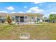 View of the backyard featuring a patio with screen and lush landscaping under a bright sky at 3901 41St W St, Bradenton, FL 34205