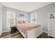 Comfortable bedroom with a white bed frame, pink bedding, and natural light from the two windows at 3901 41St W St, Bradenton, FL 34205