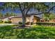 Charming single-story home with lush landscaping, mature trees, and a well-manicured lawn at 3914 Glen Oaks Manor Dr, Sarasota, FL 34232