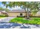 Inviting single-story home featuring a 1-car garage, lush landscaping, and a beautiful shade tree at 3914 Glen Oaks Manor Dr, Sarasota, FL 34232
