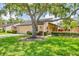 Charming single-story home with lush landscaping, mature trees, and a well-manicured lawn at 3914 Glen Oaks Manor Dr, Sarasota, FL 34232