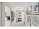 Bright hallway featuring tile flooring and decorative wall art leading to the kitchen at 3914 Glen Oaks Manor Dr, Sarasota, FL 34232