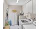 Bright laundry room with modern washer and dryer, ample storage cabinets, and a utility sink for added convenience at 3914 Glen Oaks Manor Dr, Sarasota, FL 34232