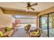 Covered lanai seating area includes a ceiling fan and overlooks an open-air screened patio at 3914 Glen Oaks Manor Dr, Sarasota, FL 34232