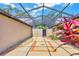 Open-air patio with brick accents, decorative gravel, landscaping, and screened enclosure with a bright sky overhead at 3914 Glen Oaks Manor Dr, Sarasota, FL 34232