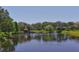 Scenic view of a tranquil pond surrounded by mature trees and lush greenery creating a relaxing atmosphere at 3914 Glen Oaks Manor Dr, Sarasota, FL 34232