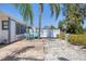 Backyard patio features a small blue table, chairs, and sunny tropical landscaping at 407 63Rd St, Holmes Beach, FL 34217