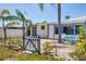 Charming home with white picket fence, lush green plants and a blue table and chairs at 407 63Rd St, Holmes Beach, FL 34217