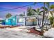 Charming coastal home featuring a carport, colorful accents, and tropical landscaping at 407 63Rd St, Holmes Beach, FL 34217