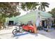 Vintage red car parked outside the light-green retail storefront with surfboards at 407 63Rd St, Holmes Beach, FL 34217