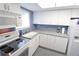 Well-lit kitchen with white cabinets and appliances, plus light countertops at 4154 Heron Way # 203B, Bradenton, FL 34205