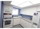Bright kitchen featuring white cabinets, appliances, and a window for natural light at 4154 Heron Way # 203B, Bradenton, FL 34205