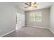 Cozy bedroom featuring neutral carpet, ceiling fan, and a bright window with plantation shutters at 4220 Via Piedra Cir # 4-101, Sarasota, FL 34233