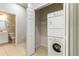 Convenient laundry area with stacked washer and dryer, adjacent to a well-lit bathroom at 4220 Via Piedra Cir # 4-101, Sarasota, FL 34233