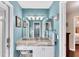 Bathroom featuring blue walls, a large mirror, marble countertops and stylish fixtures at 4585 Dover Street E Cir, Bradenton, FL 34203