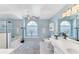 Airy main bathroom with double sinks, a soaking tub, and a walk-in shower with a glass door at 4585 Dover Street E Cir, Bradenton, FL 34203