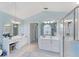 Well-lit main bathroom with dual vanities, a glass-enclosed shower, and a separate toilet room at 4585 Dover Street E Cir, Bradenton, FL 34203