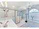 Bright main bathroom offering a walk-in shower, garden tub, and modern lighting fixtures at 4585 Dover Street E Cir, Bradenton, FL 34203
