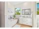 Bright bathroom featuring a soaking tub, double sink vanity, and a view of the outdoors at 5365 Craig Ter, Port Charlotte, FL 33981