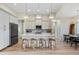 Modern kitchen featuring an island with seating, stainless steel appliances, stylish pendant lighting, and white cabinetry at 5365 Craig Ter, Port Charlotte, FL 33981