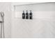 Close up of shower fixtures, with decorative tile niche, holding shampoo, conditioner, and body soap at 5365 Craig Ter, Port Charlotte, FL 33981
