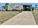 Charming single-story home with a long driveway, carport, and manicured lawn at 5511 Denmark Dr, Bradenton, FL 34207
