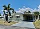 Charming home with a covered carport, beautiful palm trees, and well-maintained landscaping at 5511 Denmark Dr, Bradenton, FL 34207