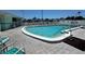 Community outdoor pool area with surrounding patio furniture and a white picket fence at 5511 Denmark Dr, Bradenton, FL 34207