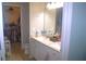 Bathroom with double sinks, white cabinets and a walk-in closet at 5681 Bidwell Pkwy # 104, Sarasota, FL 34233