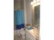Bathroom featuring neutral tile, with coordinated blue shower curtain and countertop accents at 5681 Bidwell Pkwy # 104, Sarasota, FL 34233