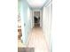 Long hallway with plank floors and several white closet doors at 5681 Bidwell Pkwy # 104, Sarasota, FL 34233