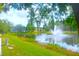 Scenic view of pond with fountain surrounded by lush greenery and townhomes at 5681 Bidwell Pkwy # 104, Sarasota, FL 34233