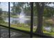 Charming view of serene pond with fountain framed by lush trees at 5681 Bidwell Pkwy # 104, Sarasota, FL 34233