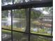 Screened-in porch view of a tranquil pond with fountain and lush landscaping at 5681 Bidwell Pkwy # 104, Sarasota, FL 34233