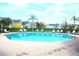 Community pool with plenty of lounge chairs and manicured landscaping at 5681 Bidwell Pkwy # 104, Sarasota, FL 34233