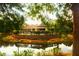 Scenic view of the pool overlooking the lake with a decorative fence and beautiful building in the background at 5681 Bidwell Pkwy # 104, Sarasota, FL 34233