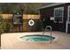 Outdoor spa tub surrounded by fencing, landscaping, and posted spa rules and hours at 5681 Bidwell Pkwy # 104, Sarasota, FL 34233