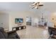 Open-concept living room features tile floors, a ceiling fan, and access to the kitchen and dining areas at 613 E 49Th E St, Bradenton, FL 34208