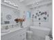 Bright white bathroom with a freestanding tub, chandelier, decorative mirror, and palm tree art at 643 Calle Del Otono, Sarasota, FL 34242